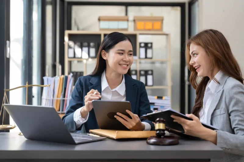 An adviser gesturing while explaining a document to a client across a desk