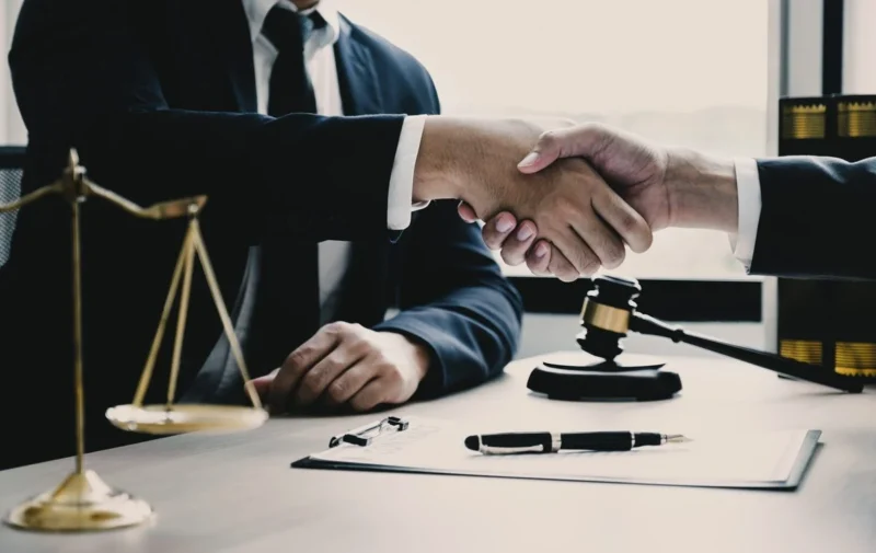 An adviser pointing at a printed agreement while a client signs