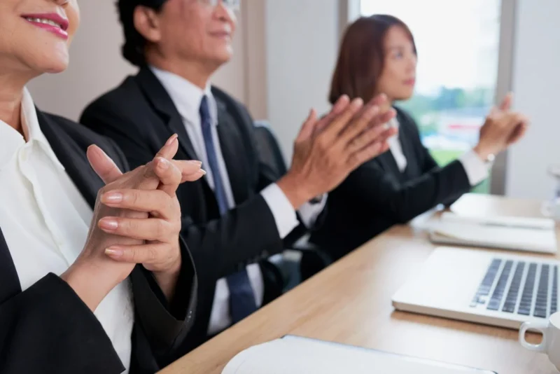 Seated colleagues applauding at a presentation