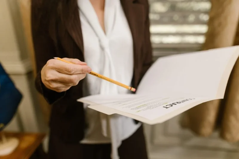 A gavel on a desk beside a laptop and case files