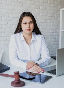 A solicitor at a desk with a laptop, tablet and gavel